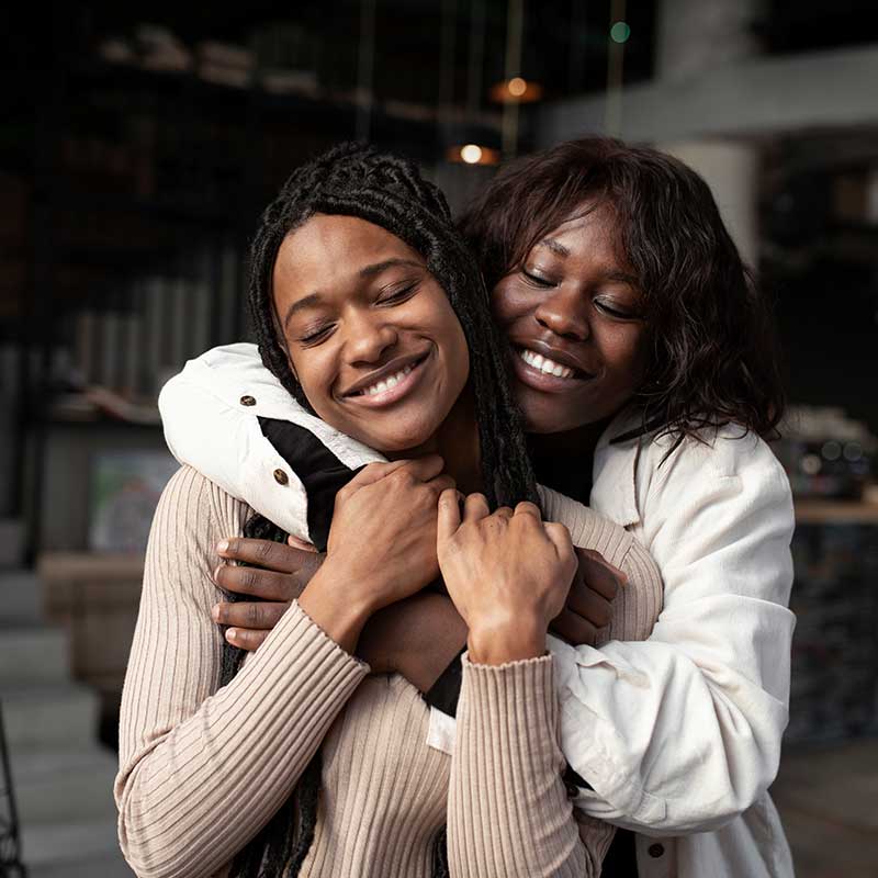 Two women embracing, smiling warmly