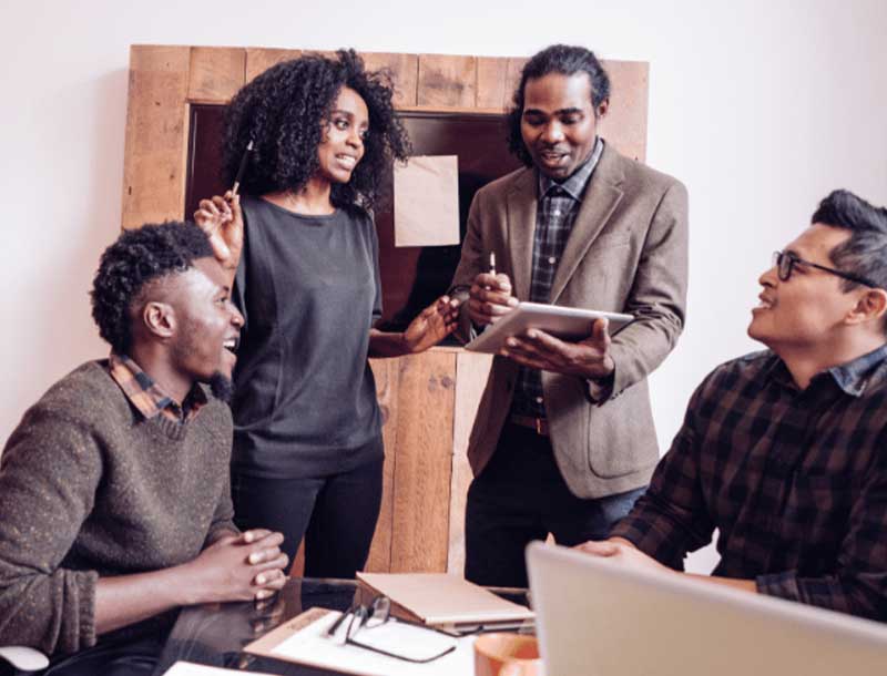 A diverse team in conversation around a workplace meeting