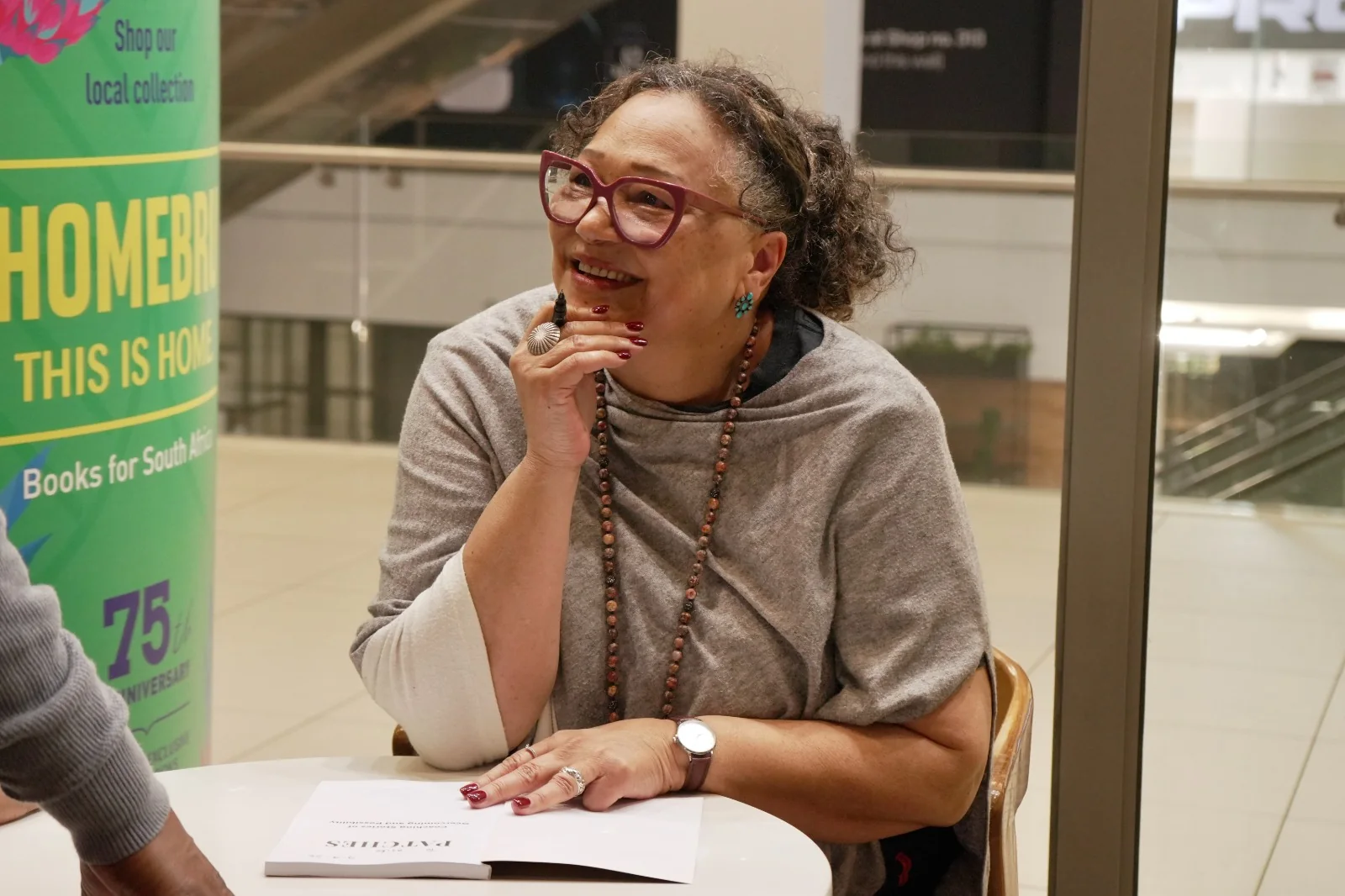 Alicia S. Pieterse at the signing table with a copy of Patches